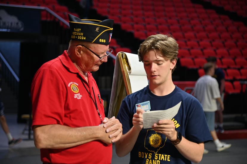 High school student pointing at a paper, explaining something to a veteran