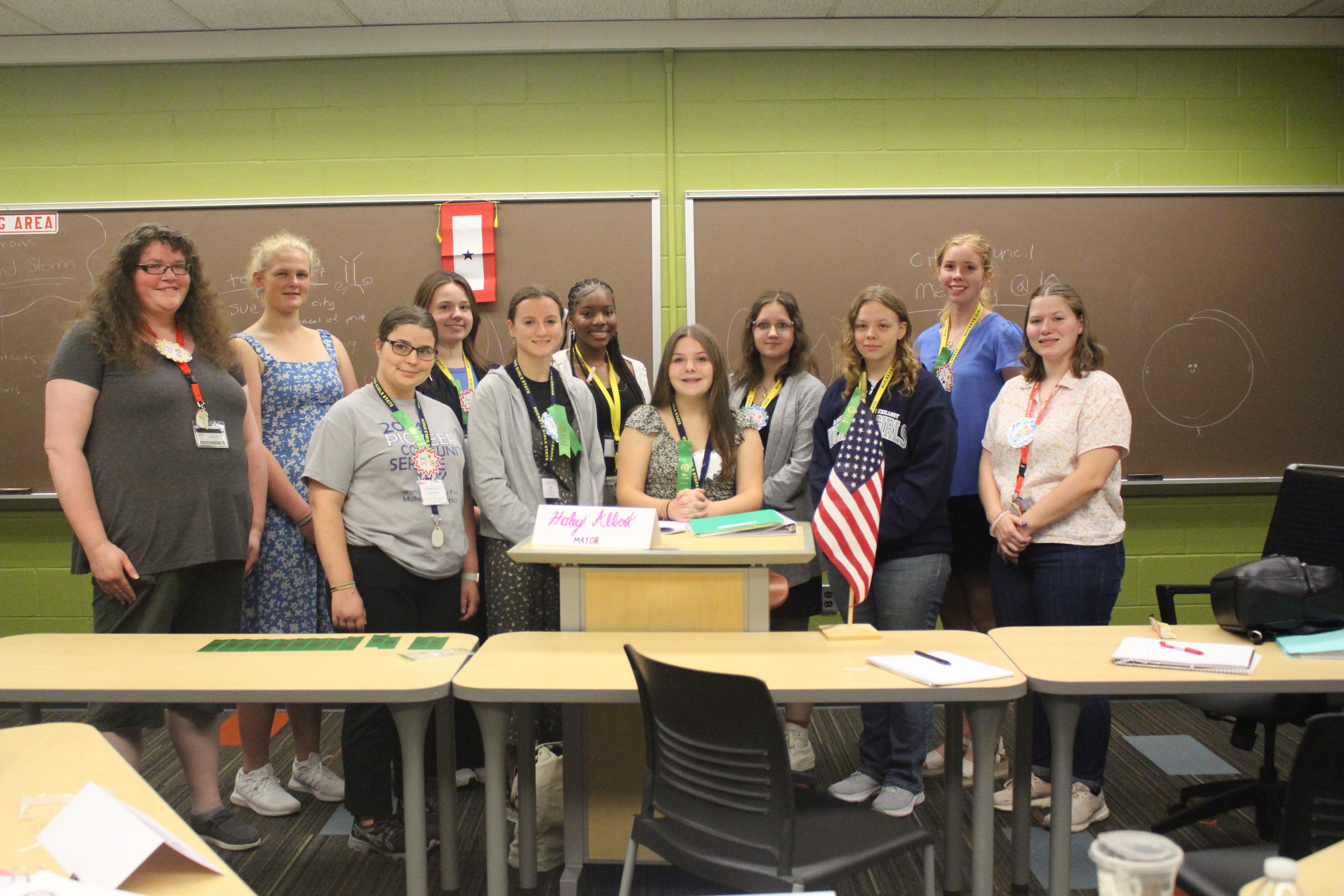 A group of several students smiling in front of a classroom at Bowling Green State University