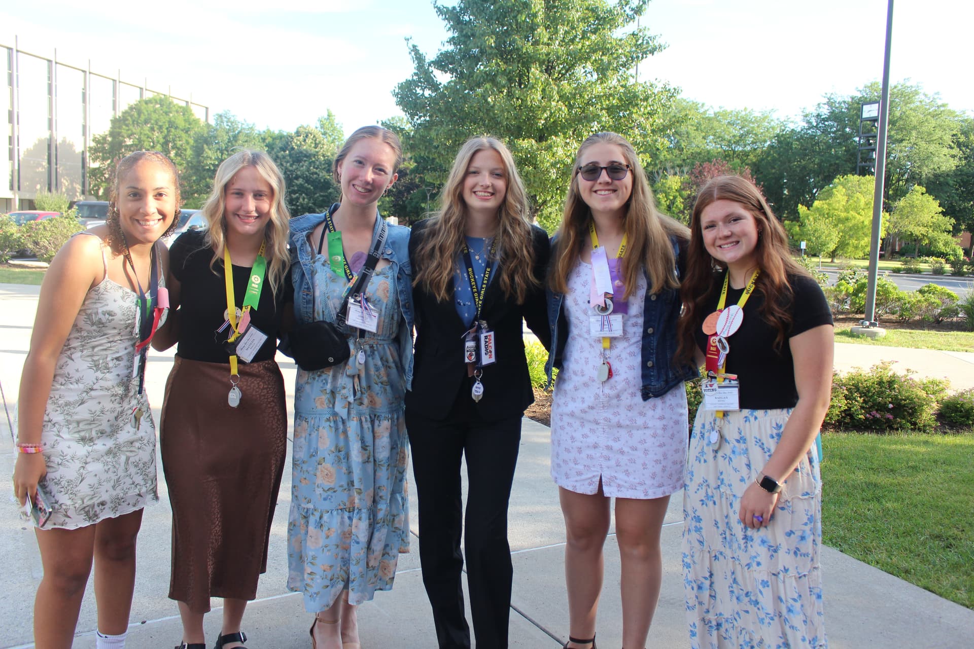 Several students in suits smiling outside