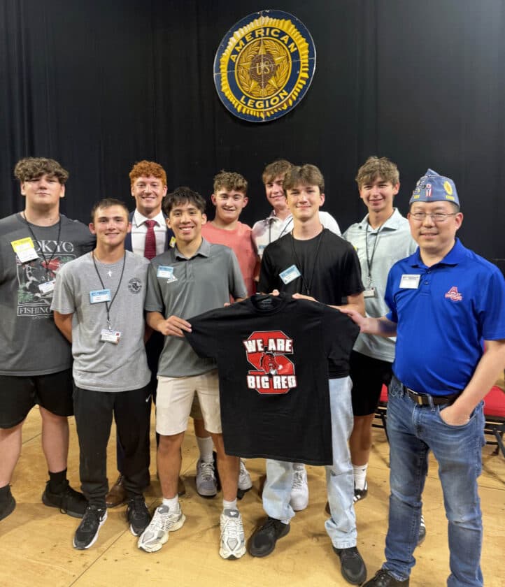 Group of Steubenville-area Buckeye Boys State delegates posing with a 'We Are Big Red' t-shirt and an American Legion staff member
